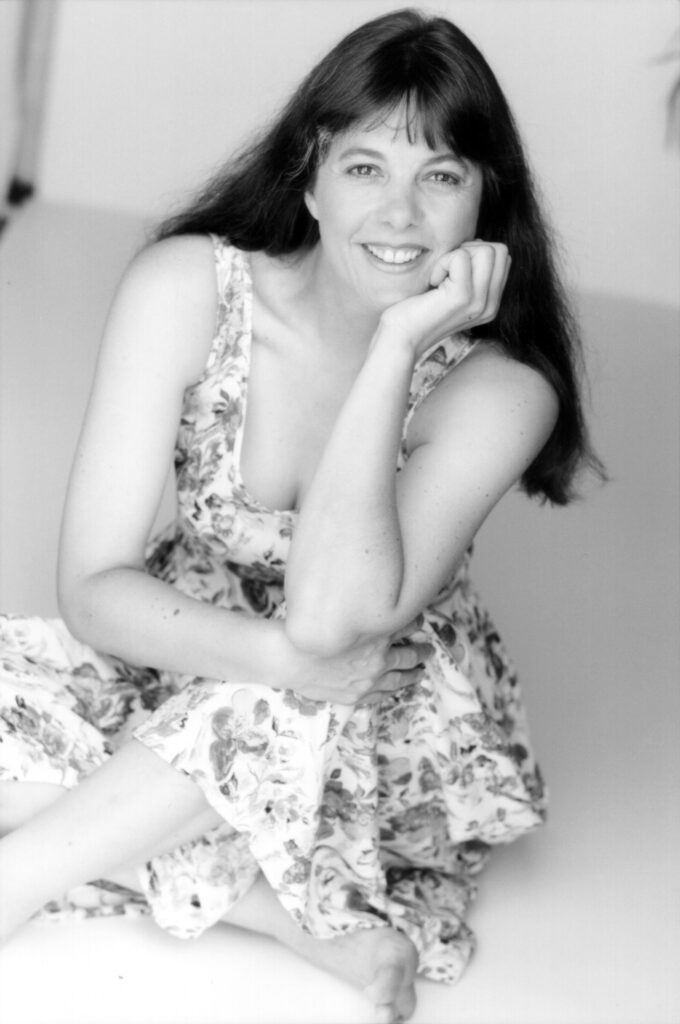1998. Sitting on the floor in a floral dress.