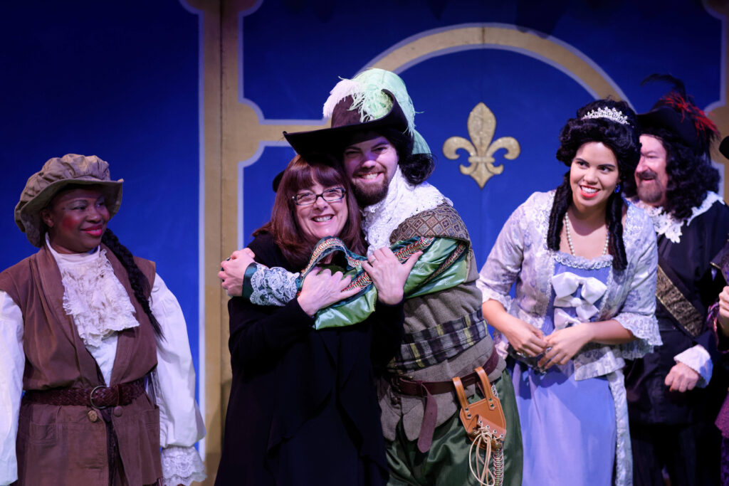 Hug from a cast member as others look on.