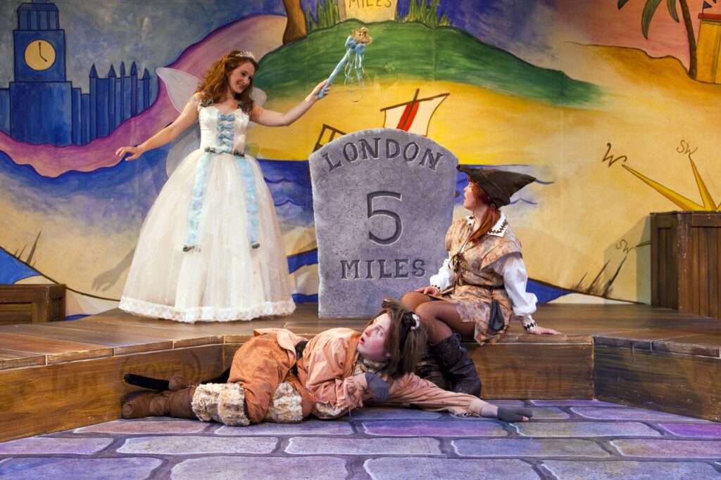 A fairy stands over Dick Whittington and his cat.